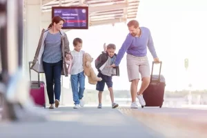 0_Family-walking-pulling-suitcases-at-train-station